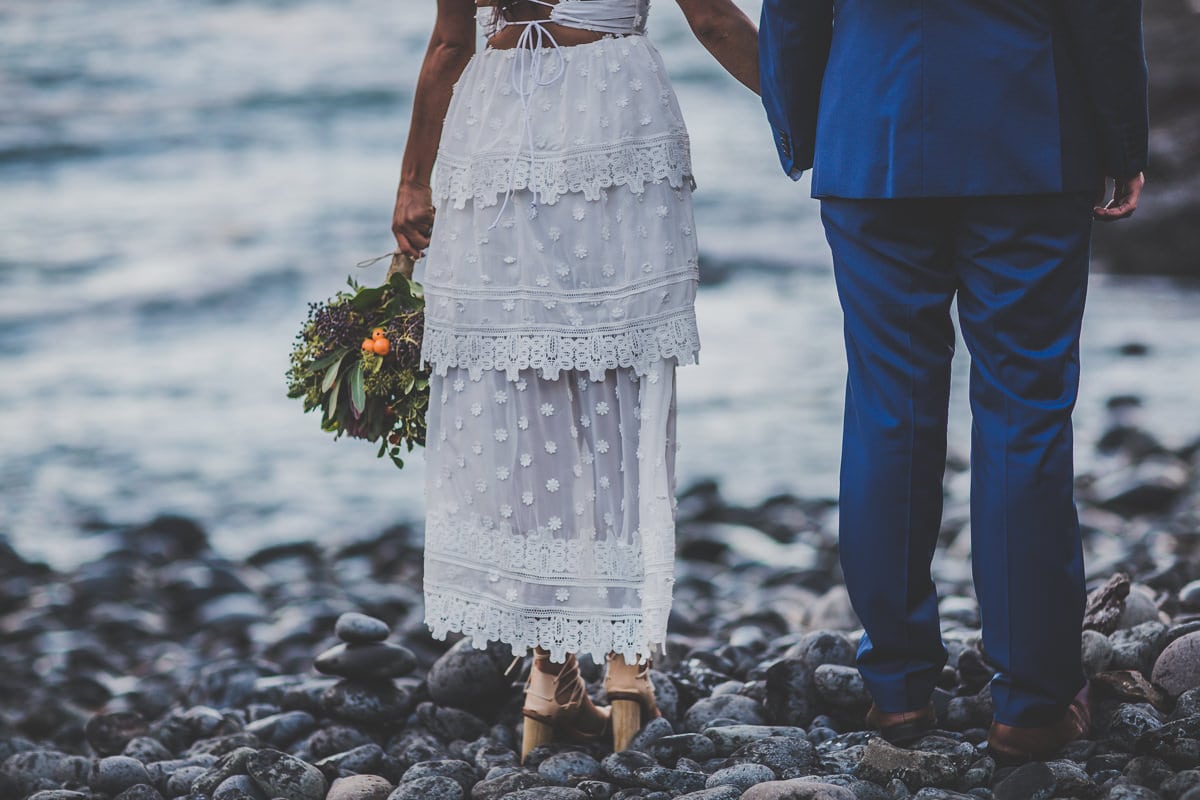 bride and groom standing at the ocean 