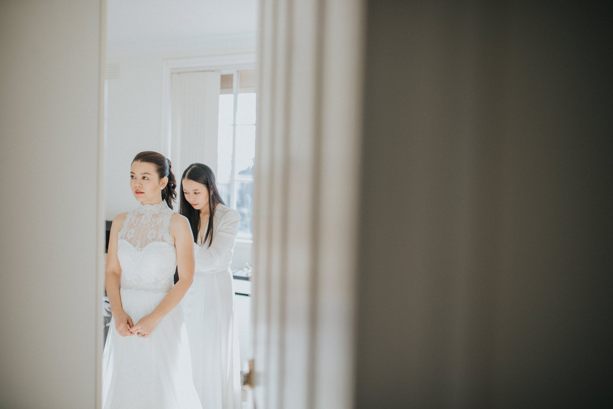 bride and bridesmaid getting dressed - wedding photojournalism